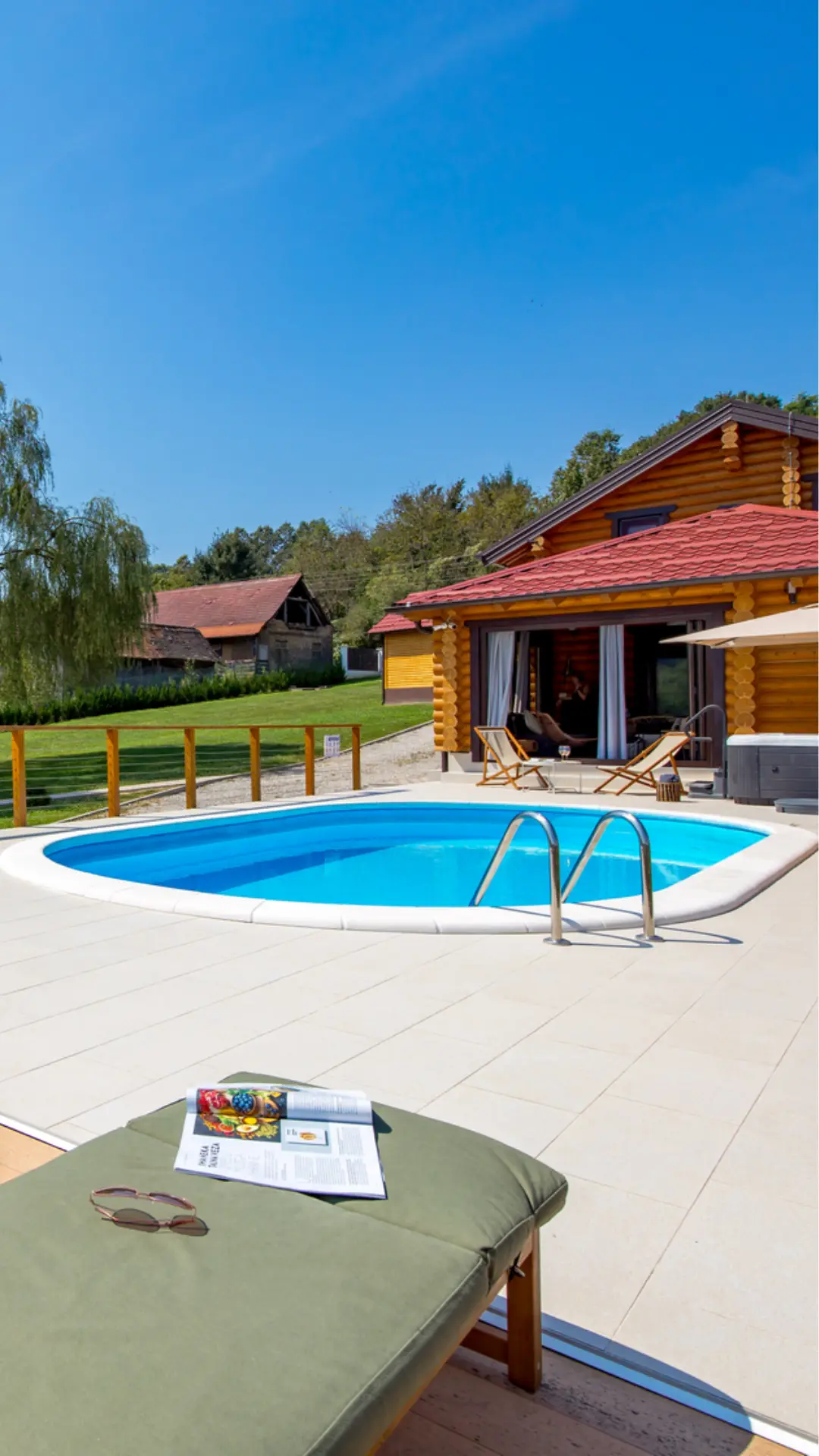 Pool beside the Babylonica wooden house, with a sun lounger in front