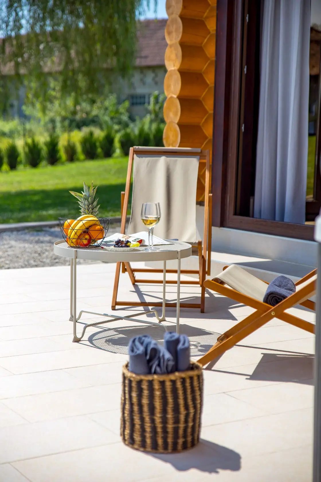Deck chair and side table by the house's glass doors
