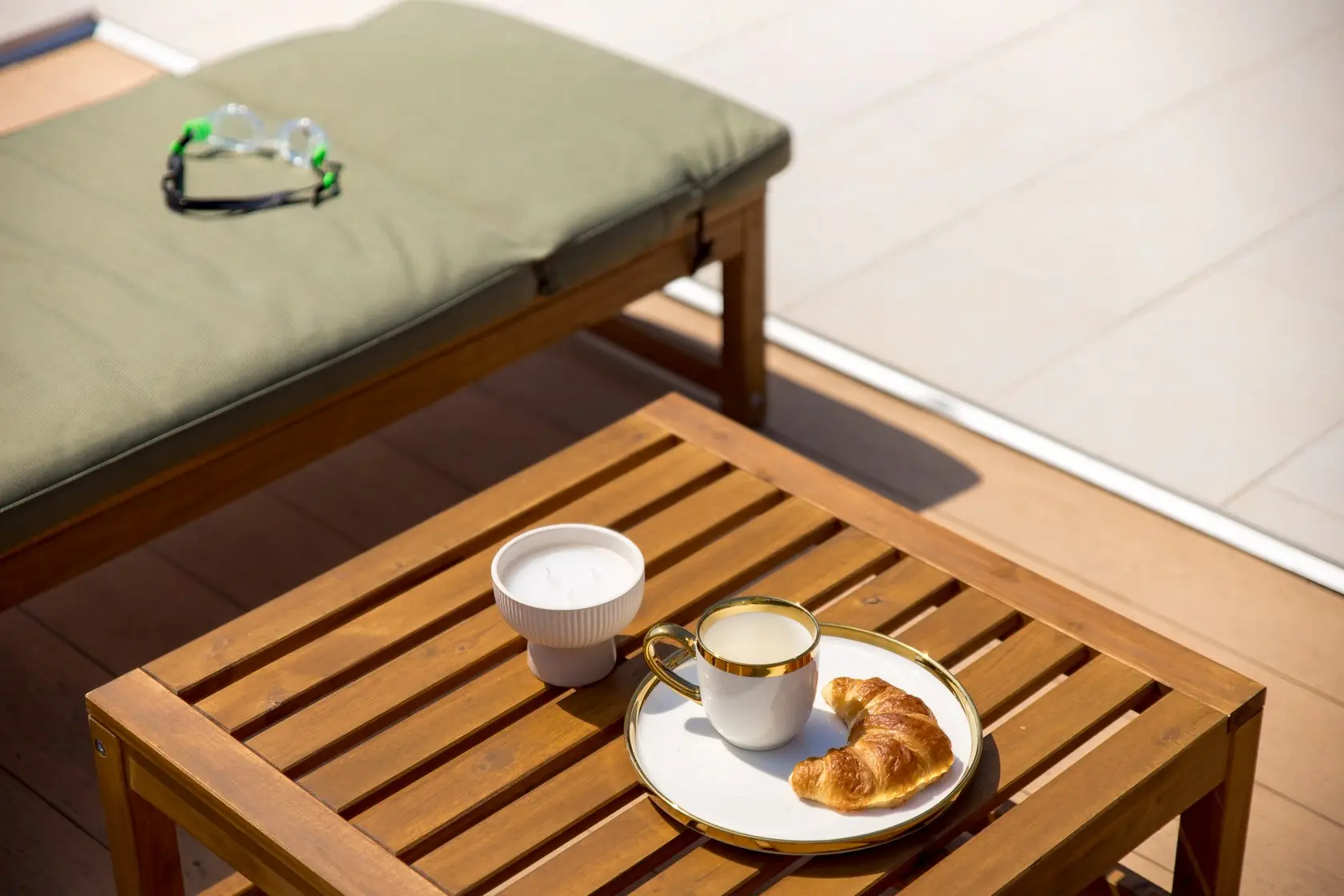 Coffee and a croissant beside a poolside lounger