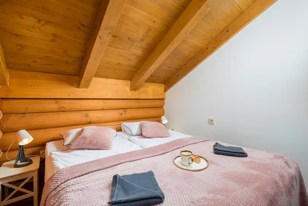 Spavaća soba s krevetom pod drvenim stropom