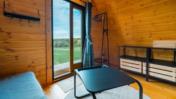 Glamping cabin interior with a view through the glass door