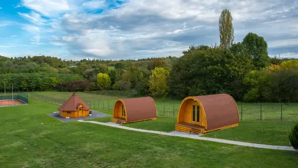 Two glamping cabins and the barbecue hut joined by a path