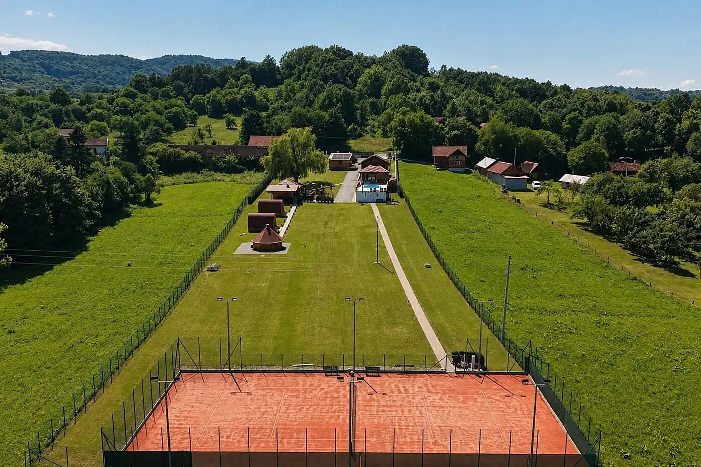 The estate from above: tennis court, barbecue hut, two glamping cabins and the house with pool