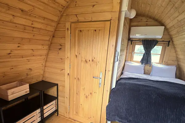 Inside a glamping cabin: double bed, window and air conditioning