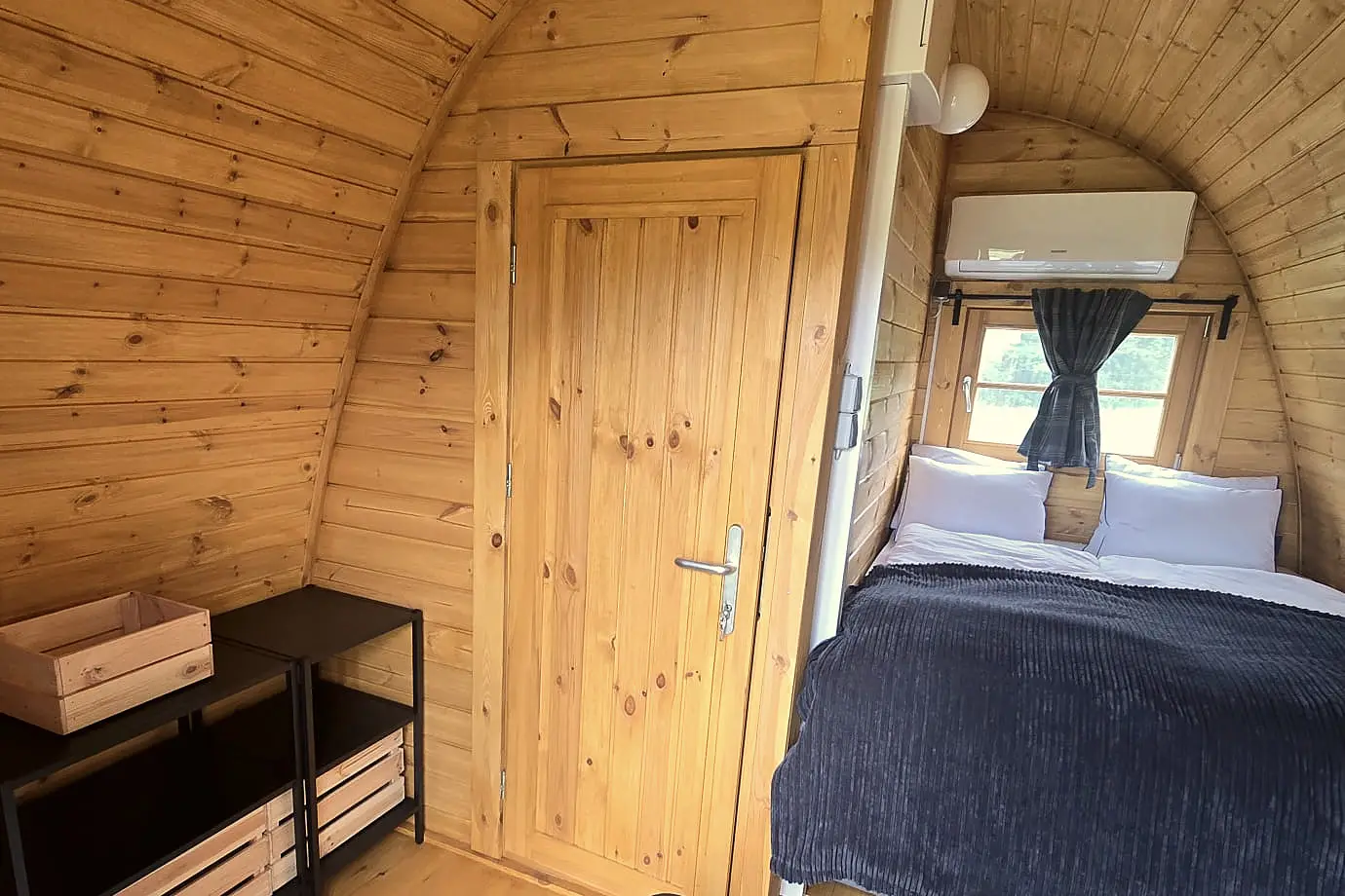 Inside a glamping cabin: double bed, window and air conditioning
