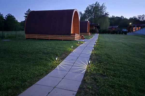 Solar-lit path past the glamping cabins at dusk